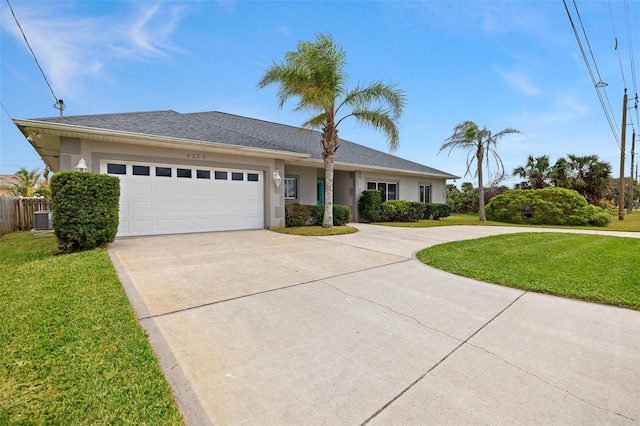 view of front of property featuring a front yard, central AC, and a garage