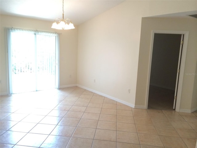 spare room with a chandelier and light tile flooring