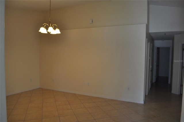 tiled empty room with a notable chandelier