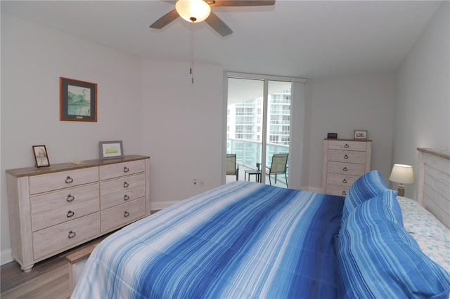 bedroom featuring expansive windows, ceiling fan, and light wood-type flooring