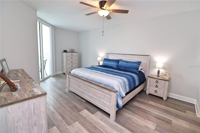 bedroom featuring multiple windows, wood-type flooring, and ceiling fan