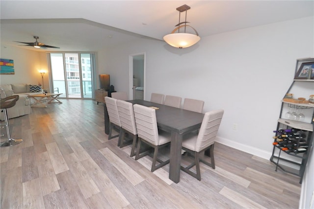 dining room with vaulted ceiling, light hardwood / wood-style floors, and ceiling fan