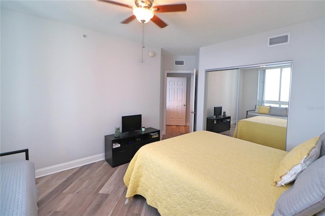 bedroom with a closet, hardwood / wood-style floors, and ceiling fan