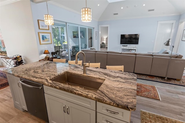 kitchen with lofted ceiling, white cabinetry, an inviting chandelier, light hardwood / wood-style flooring, and light stone counters