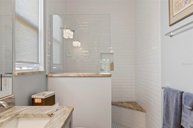 bathroom with vanity and tiled shower