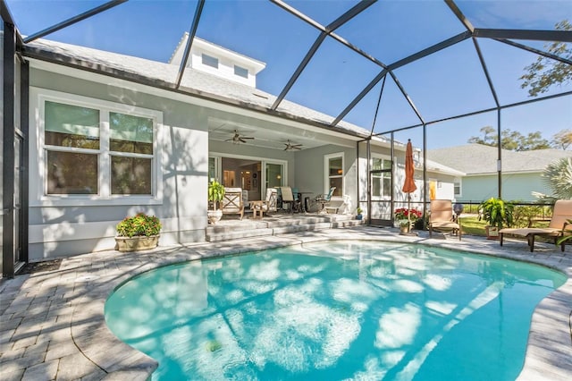 view of swimming pool with a patio, a lanai, and ceiling fan