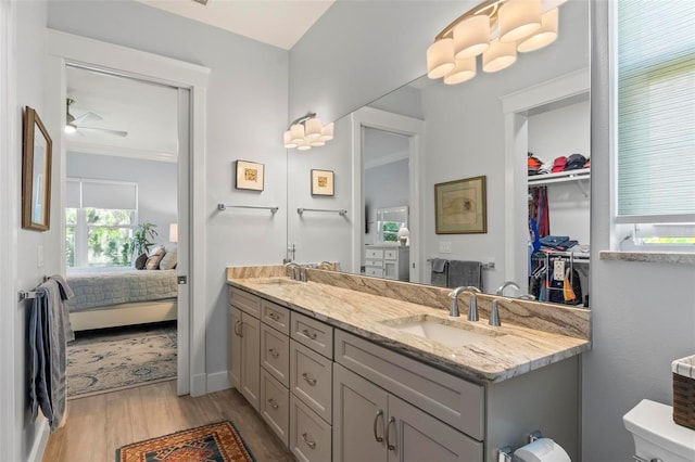 bathroom featuring ornamental molding, dual vanity, ceiling fan, and hardwood / wood-style flooring