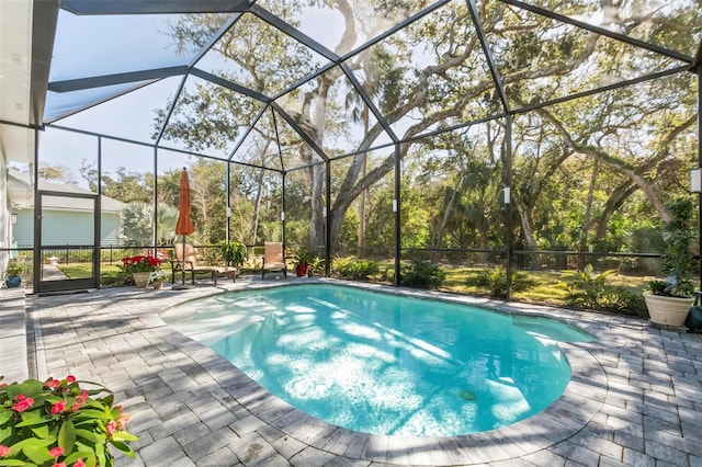 view of pool featuring glass enclosure and a patio area