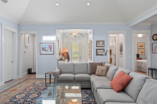 living room with lofted ceiling, ornamental molding, and light wood-type flooring