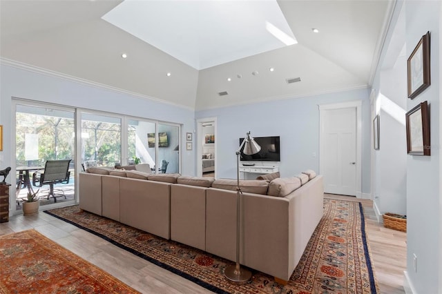 living room with high vaulted ceiling, ornamental molding, and light hardwood / wood-style flooring