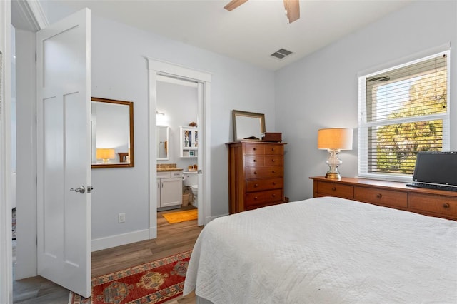 bedroom with light hardwood / wood-style floors, ceiling fan, and ensuite bathroom