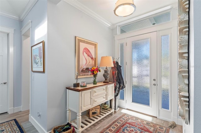 entryway with ornamental molding and light wood-type flooring