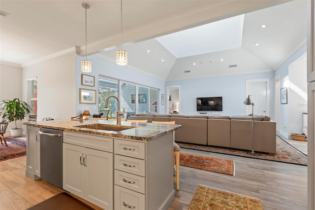 kitchen featuring stainless steel dishwasher, light stone counters, sink, and light wood-type flooring