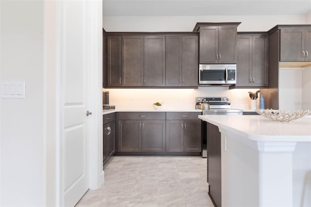 kitchen with electric stove, light tile flooring, and dark brown cabinetry