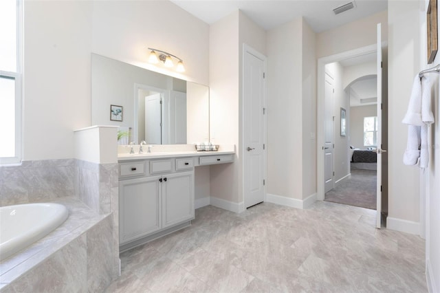 bathroom featuring tiled bath, large vanity, and tile floors