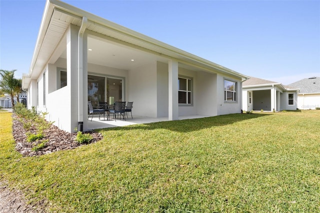 rear view of property with a lawn and a patio