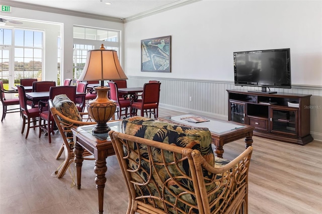 living room with ornamental molding, ceiling fan, and light hardwood / wood-style flooring