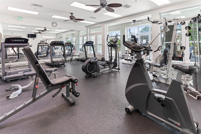 gym with ceiling fan and a textured ceiling