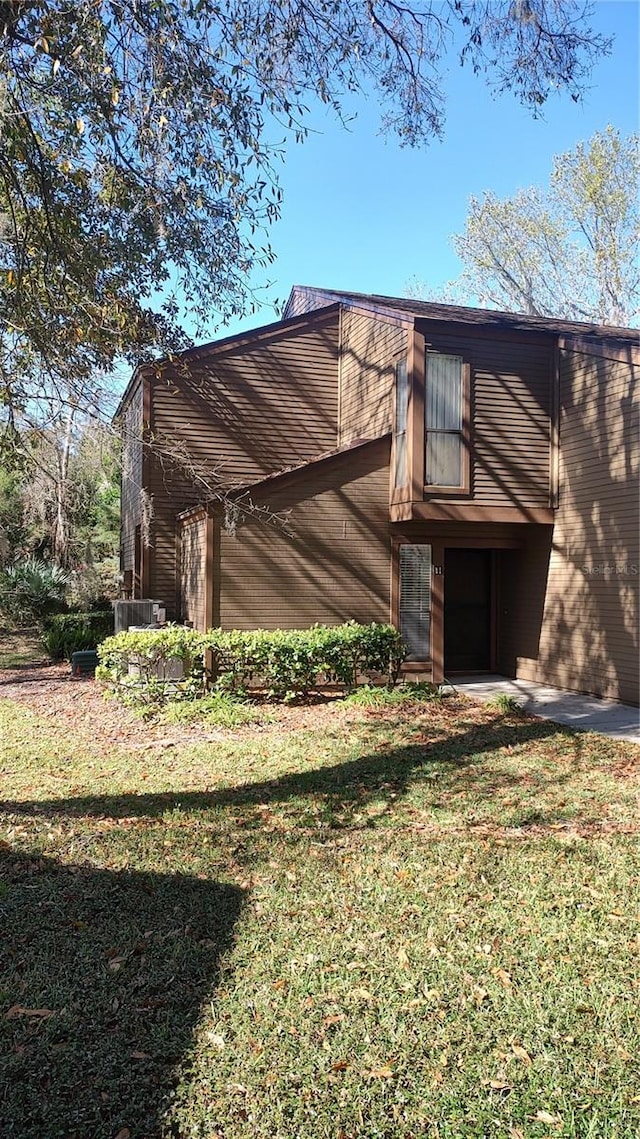 view of home's exterior featuring a yard and a balcony