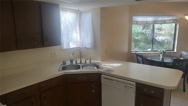 kitchen featuring kitchen peninsula, sink, dark brown cabinets, dishwasher, and light tile flooring