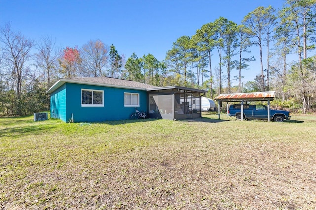 view of front of home featuring a sunroom, a front yard, and a carport