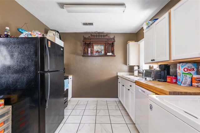 kitchen with black refrigerator, white cabinets, dishwasher, and light tile floors