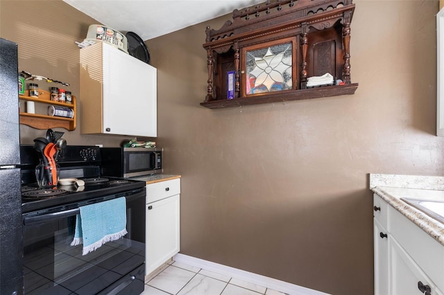 kitchen with black range with electric stovetop, white cabinetry, and light tile floors