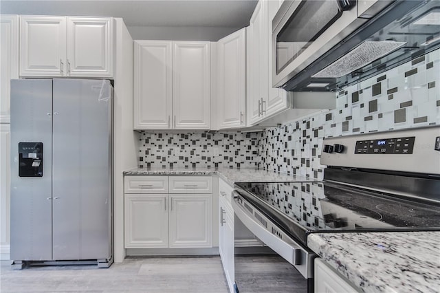 kitchen featuring appliances with stainless steel finishes, white cabinetry, light stone counters, and light hardwood / wood-style flooring