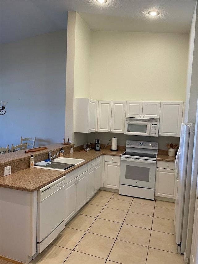 kitchen with white appliances, white cabinetry, sink, and light tile floors