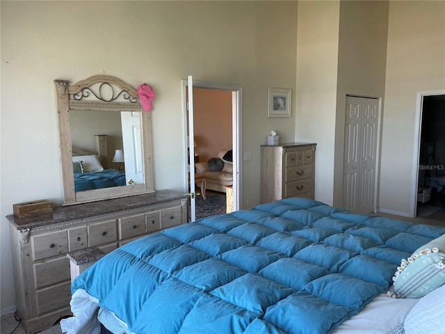 bedroom featuring a closet, carpet, and a high ceiling