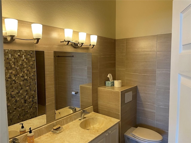 bathroom featuring tile walls, toilet, and vanity