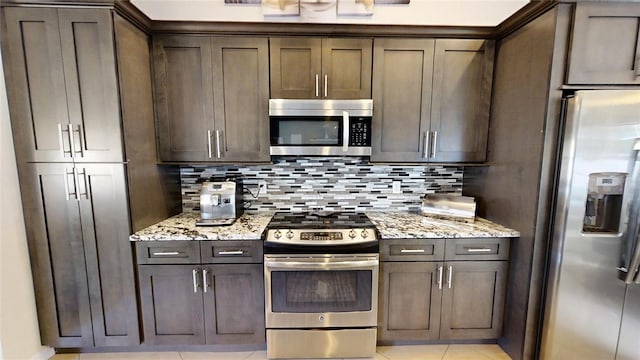 kitchen with dark brown cabinets, light stone counters, tasteful backsplash, and stainless steel appliances