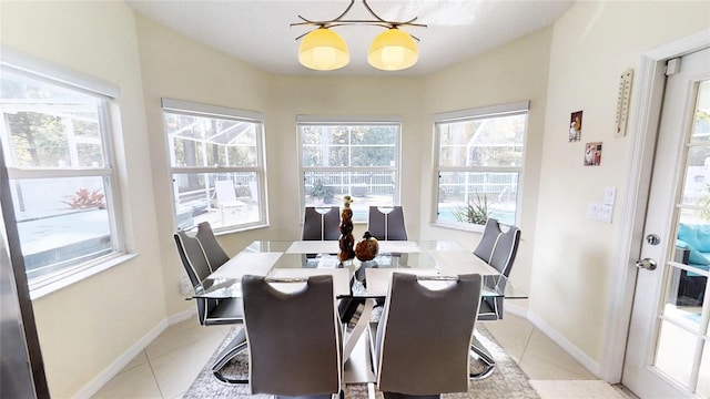 tiled dining area featuring an inviting chandelier