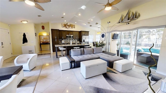 living room with light tile flooring, ceiling fan, and lofted ceiling