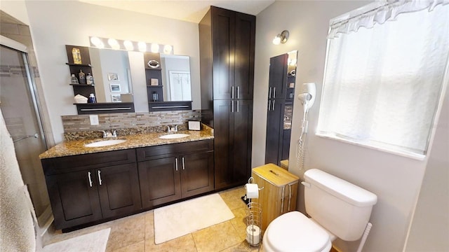 bathroom with double sink, backsplash, tile floors, toilet, and large vanity