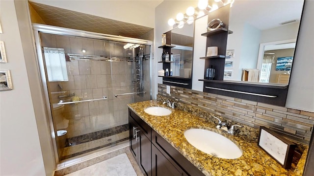 bathroom with dual sinks, a shower with door, tile flooring, tasteful backsplash, and oversized vanity