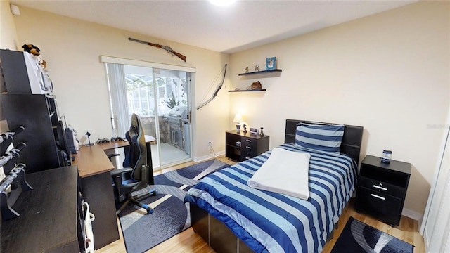 bedroom with access to outside and light hardwood / wood-style flooring