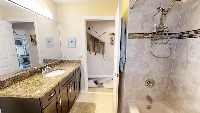 bathroom featuring vanity, tile floors, and tiled shower / bath