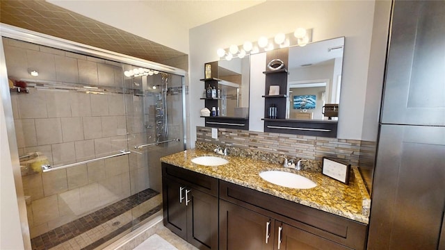 bathroom with tasteful backsplash, dual vanity, and a shower with shower door