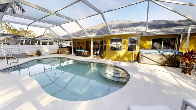 view of pool featuring a patio, glass enclosure, and a hot tub