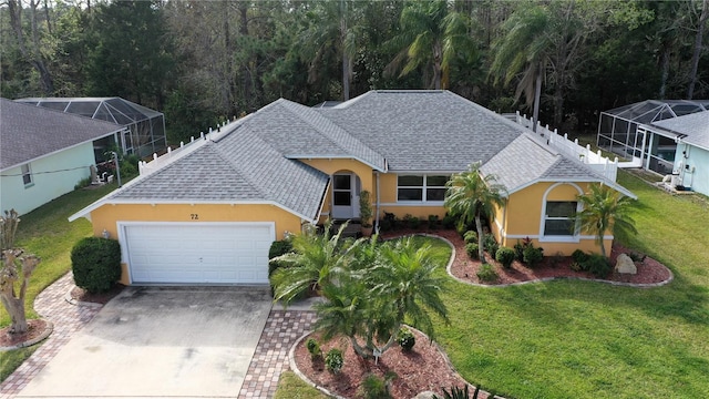 view of front of property with a front yard, a garage, and glass enclosure