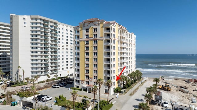 view of building exterior featuring a beach view and a water view