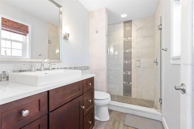 bathroom featuring a shower with door, hardwood / wood-style floors, toilet, and vanity