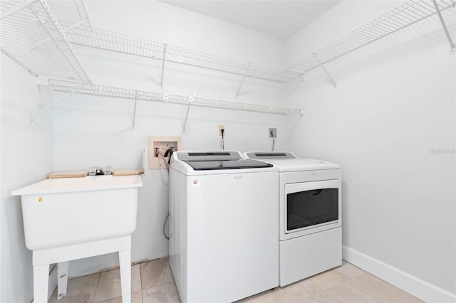 clothes washing area featuring electric dryer hookup, washer hookup, light tile floors, and washer and clothes dryer