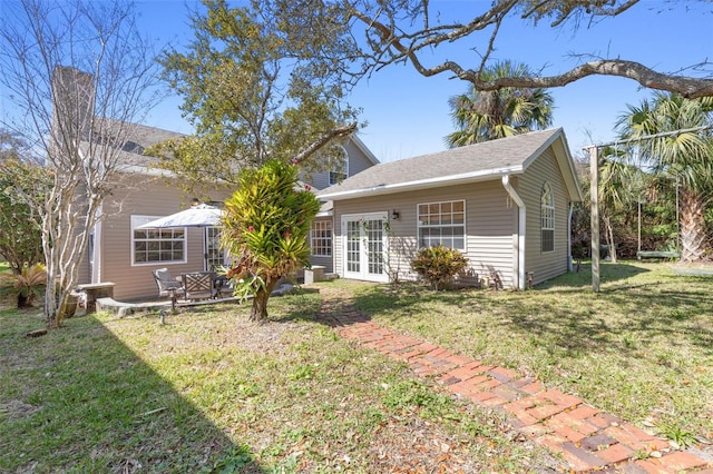 back of house featuring a yard and french doors