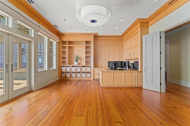 interior space featuring light hardwood / wood-style floors, crown molding, light brown cabinets, built in desk, and french doors