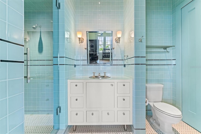 bathroom with tile patterned flooring, walk in shower, toilet, tile walls, and vanity