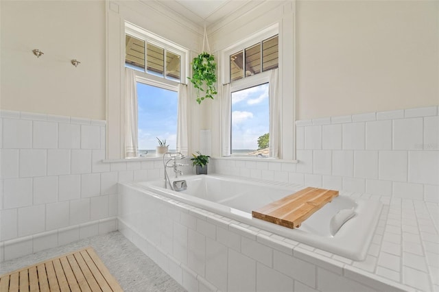 bathroom featuring crown molding and tiled tub