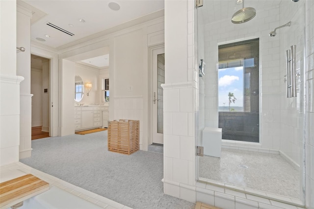 bathroom featuring walk in shower, ornamental molding, and vanity