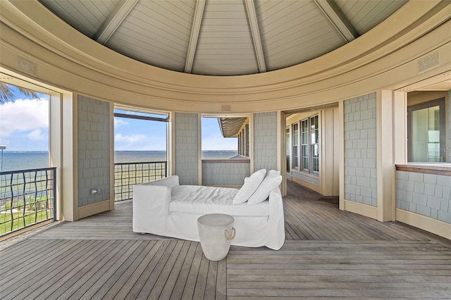 sunroom / solarium with beamed ceiling and a water view